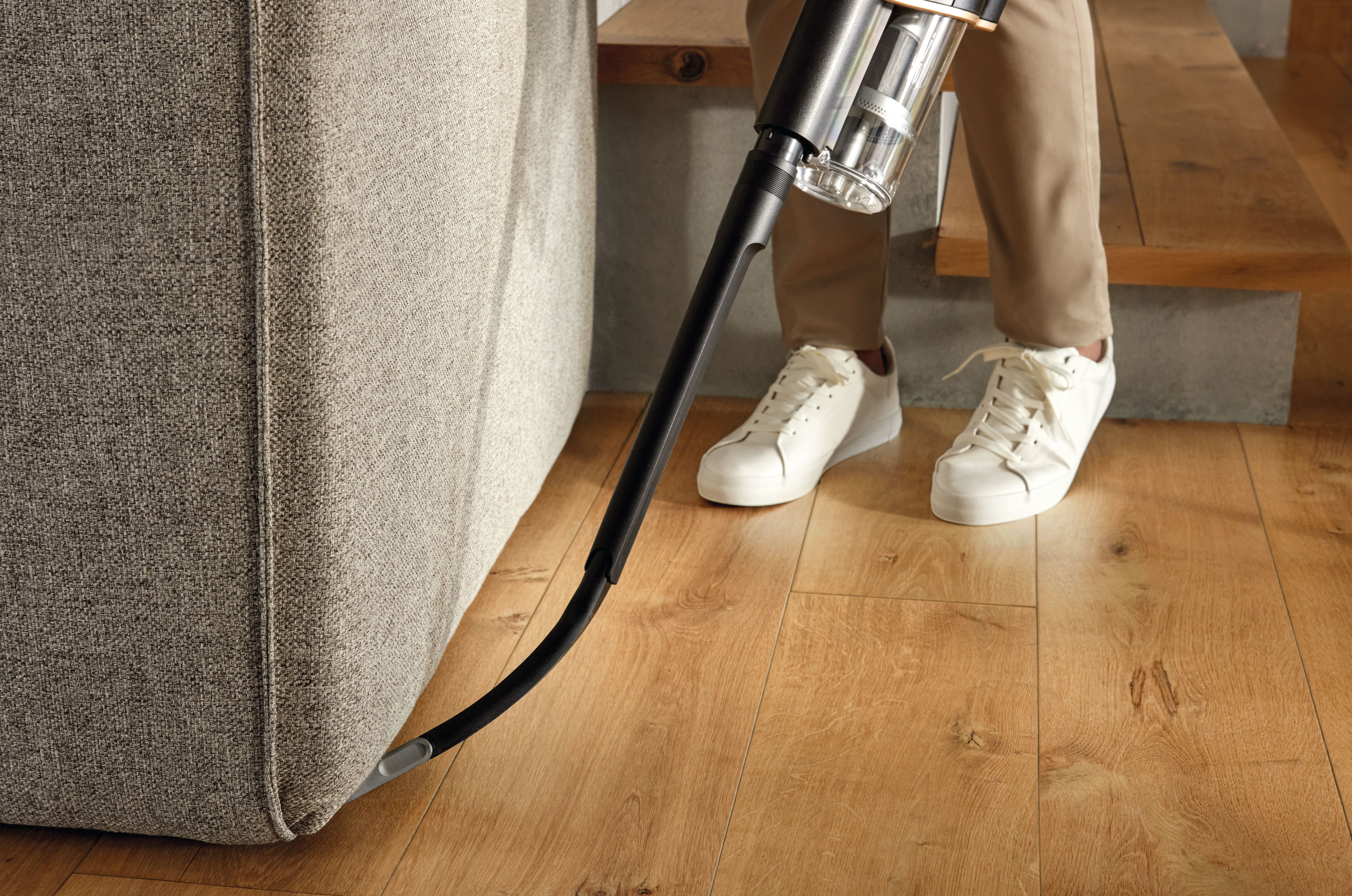 Miele HX-FCT 10 Triflex cleaning kit flex wand being used under a couch on hardwood flooring