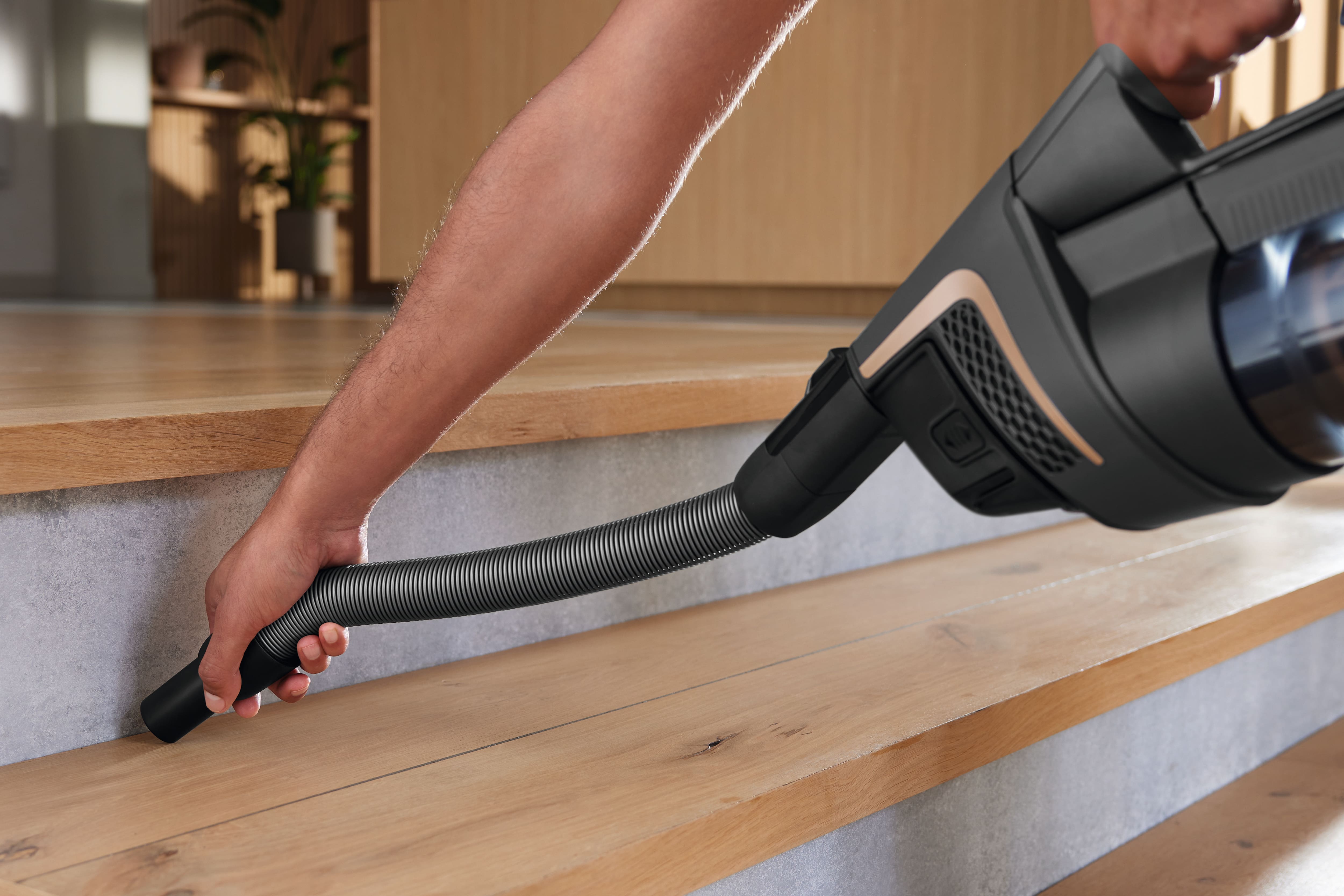 Miele HX-FCT 10 Triflex cleaning kit Hose cleaning pet hair from wood stairs with a concrete background