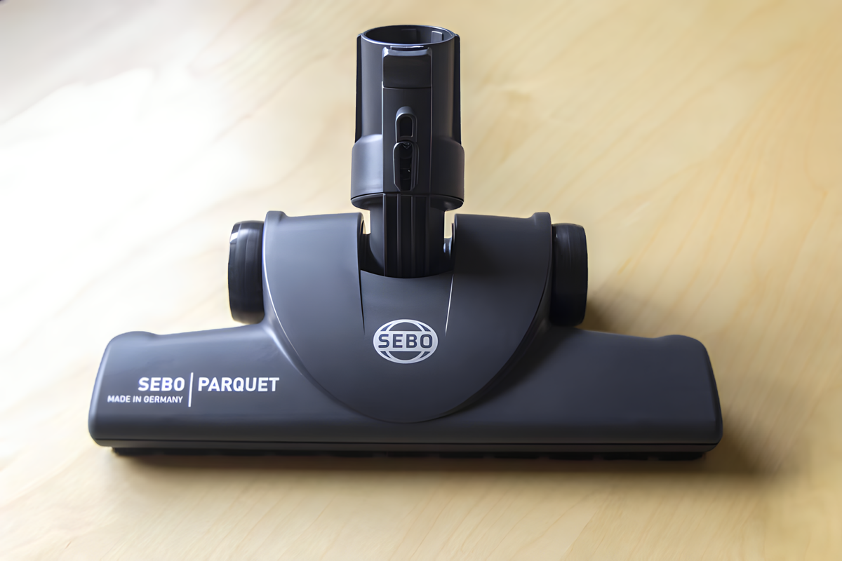 Close-up of the SEBO Parquet brush nozzle attachment for the Felix Premium upright vacuum, shown on a hardwood floor.