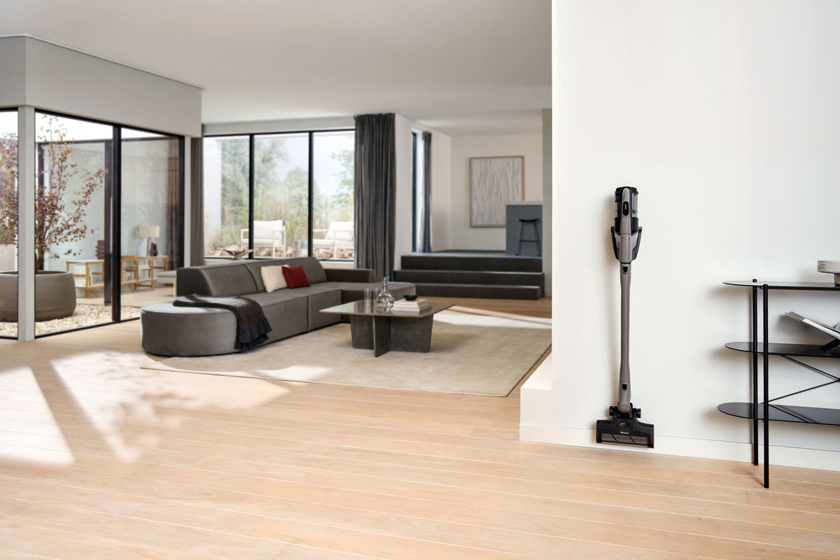Miele Triflex HX3 Hardfloor in Casa Grey standing in its park position in a sunlit living room.