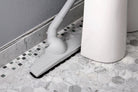 Axis floor brush on Octagon white tile floor showing how to clean behind a sink