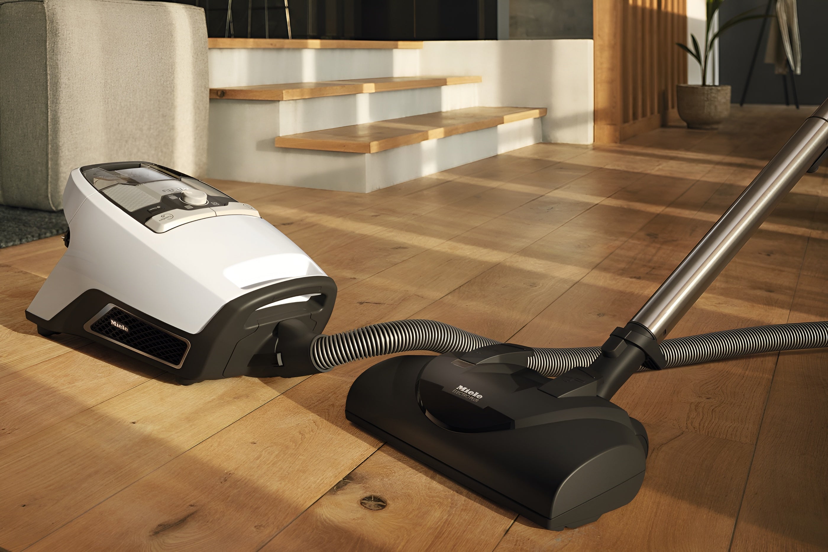 Miele Blizzard CX1 Cat & Dog Bagless Vacuum  on a wooden floor with stairs in the background