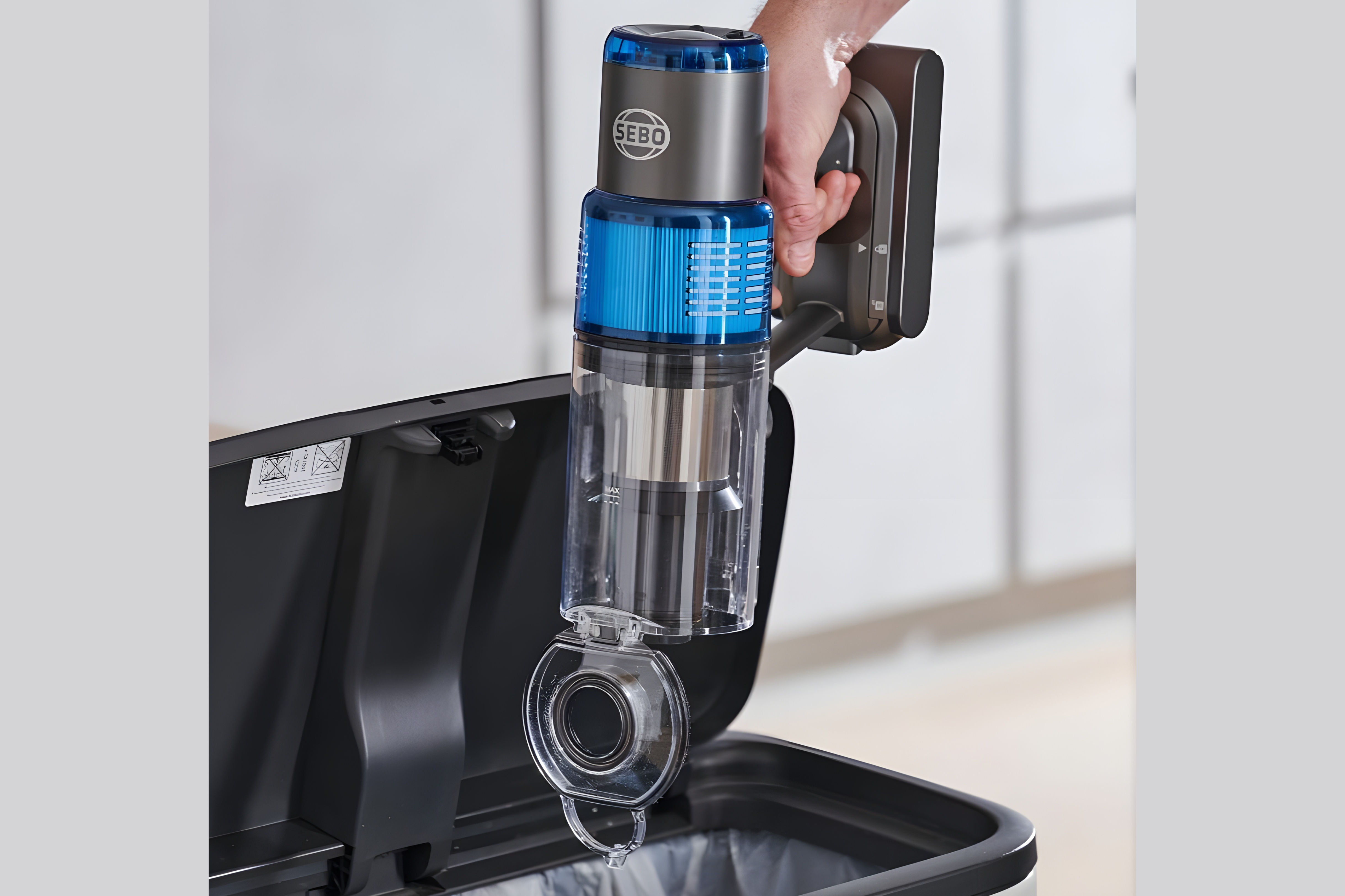 SEBO Balance A1 dust canister emptying into trash can