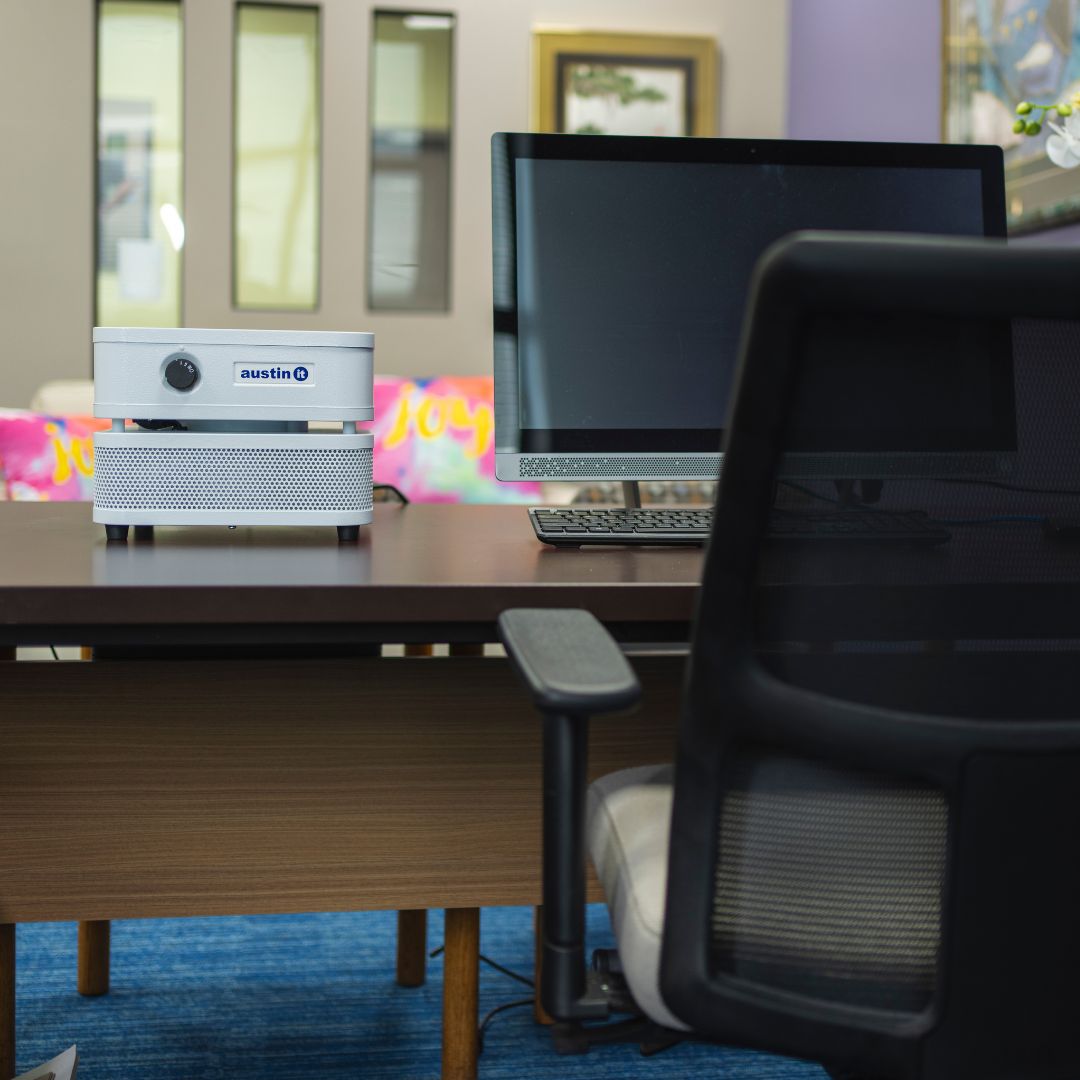 Austin Air “it” on an office desk beside a computer setup