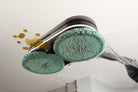 Underside of the Miele Triflex AquaTwister with two AquaPads fitted, wiping a spill from a hard floor.
