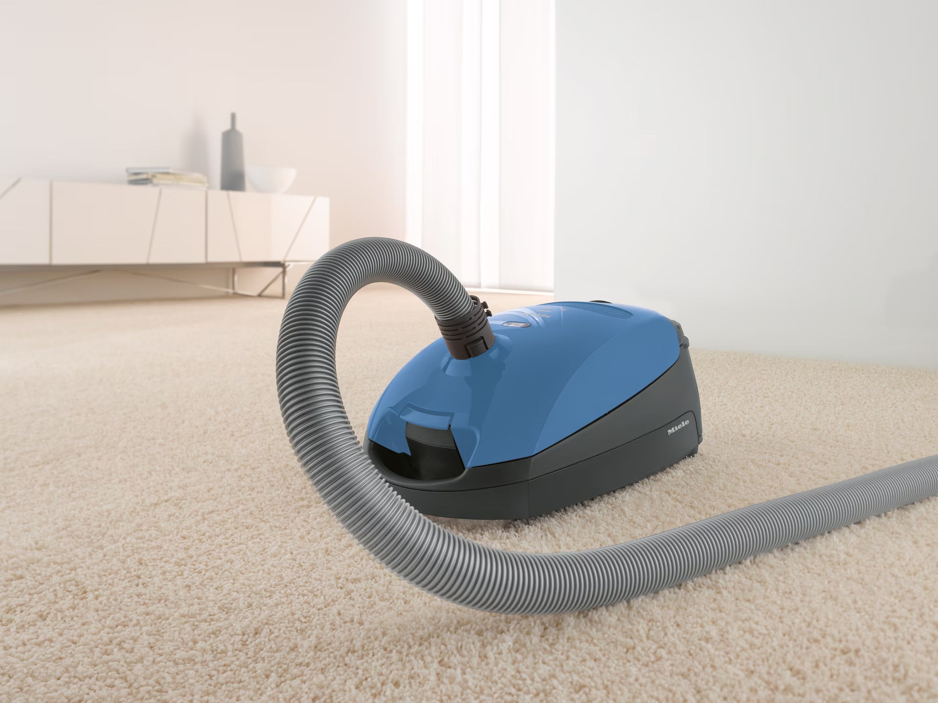 Miele Classic C1 Turbo Team in Tech Blue in a living room.
