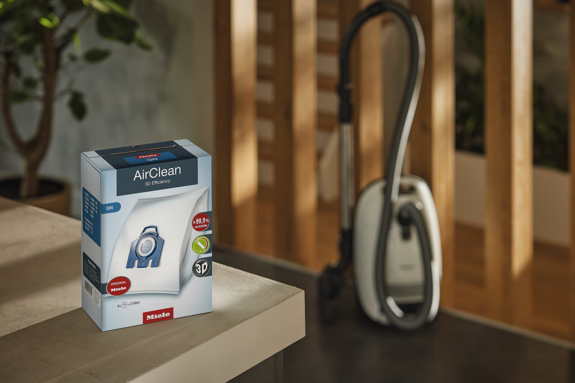 Miele AirClean GN dustbag box next to a canister vacuum.