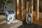 Miele AirClean GN dustbag box next to a canister vacuum.