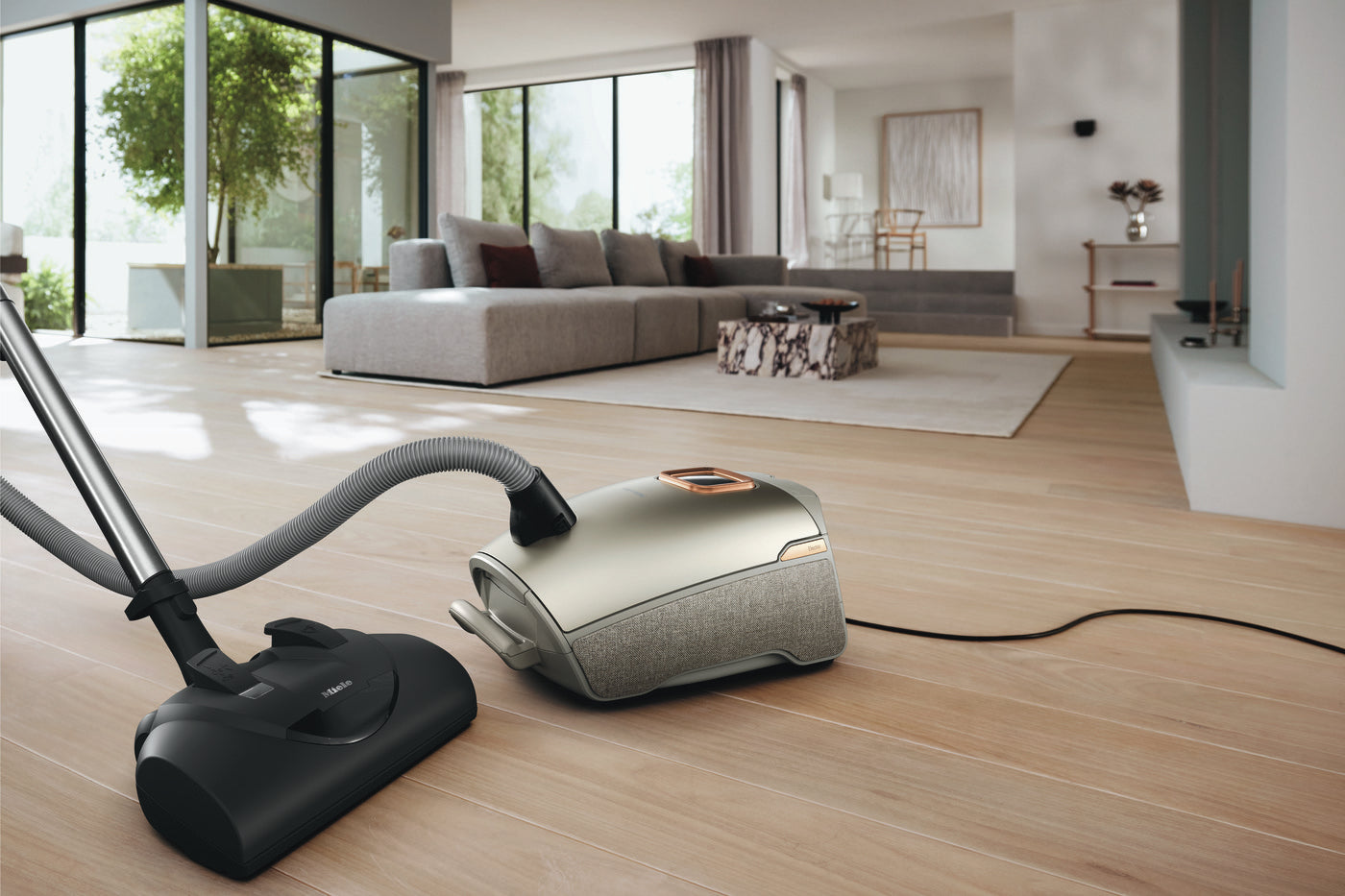 Miele Guard L1 Electro in Titanium cleaning a modern living room.