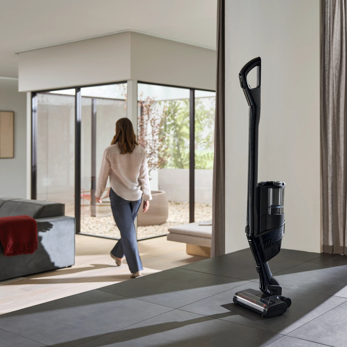 Miele Triflex HX3 Aqua standing free in a living room without a wall bracket, thanks to its park position.
