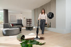 Miele Triflex HX3 Aqua vacuuming spilled potting soil from a wood floor, with a close-up of its handle controls.