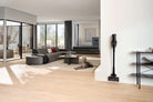 Miele Triflex HX3 Cat & Dog in Obsidian Black standing in its park position in a living room, with a dog resting on the floor nearby.