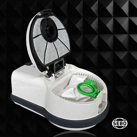 Top view of the SEBO Airbelt D Series canister vacuum with the lid open, showing the bag compartment and green sealing cap.