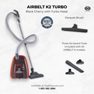 SEBO Airbelt K2 Turbo canister vacuum in black cherry with the included turbo head and parquet brush attachments.