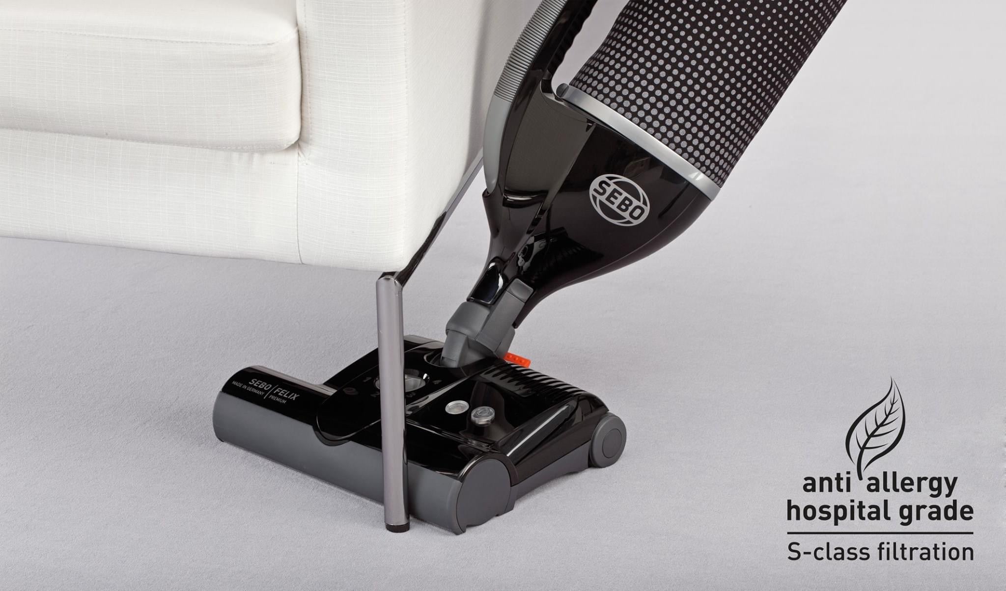 SEBO Felix Premium's handheld suction unit being used to clean carpeted stairs.