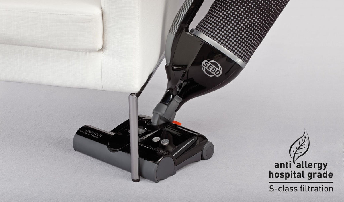 SEBO Felix Premium's handheld suction unit being used to clean carpeted stairs.