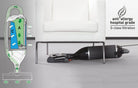 White SEBO Felix Premium upright vacuum lying flat on the floor next to a white chair, demonstrating its low-profile design for cleaning under furniture.